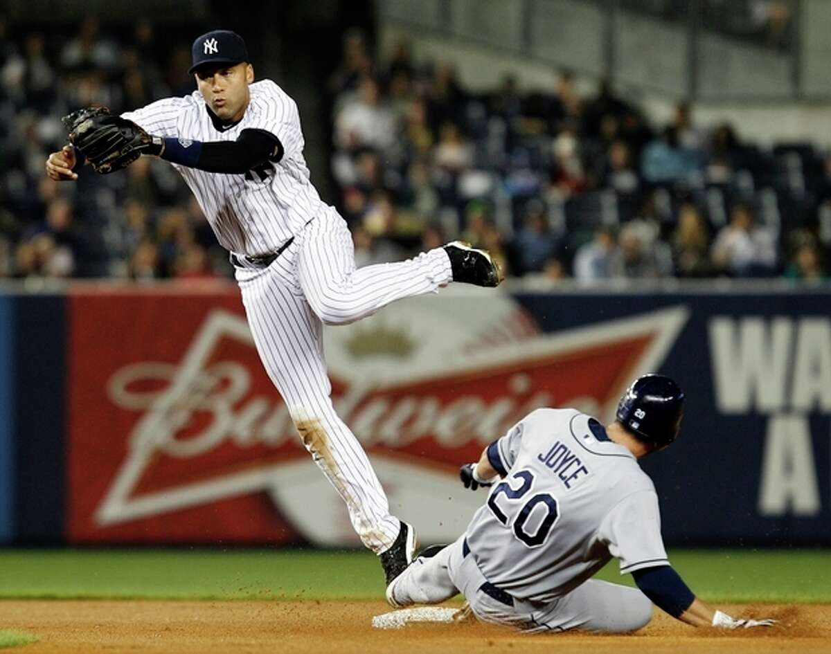 New York Yankees shortstop Derek Jeter, left, goes airborne after forcing out Tampa Bay Rays Matt Joyce at second when Rays' Luke Scott hit into a fourth-inning fielder's choice during their baseball game at Yankee Stadium in New York, Wednesday, May 9, 2012. (AP Photo/Kathy Willens)