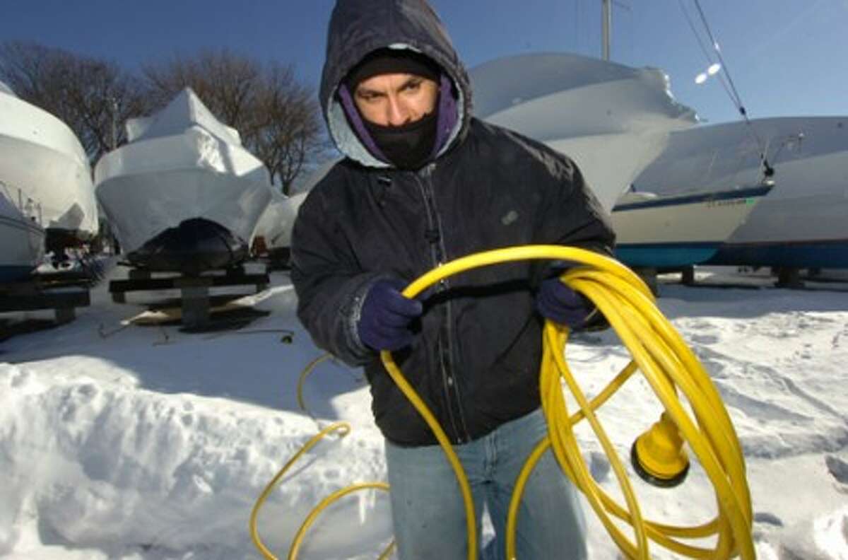 Photo/Alex von Kleydorff. Marco Vincente a Yard man with Cove Marina works at getting electrical power hooked up to a sailboat in 13 degree temps on Monday