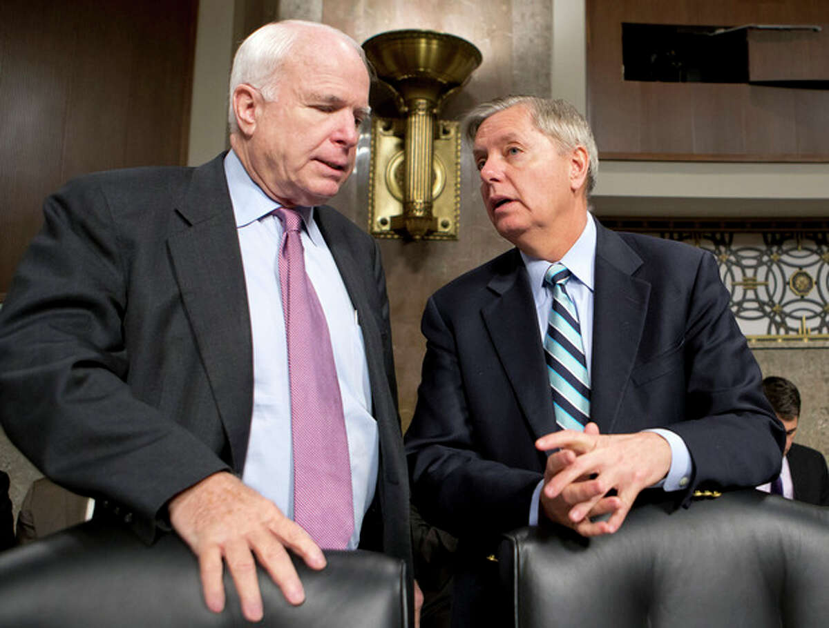 FILE - In this Feb. 14, 2013 file photo, Sen. John McCain, R-Ariz., left, and Sen. Lindsey Graham, R-S.C. confer on Capitol Hill in Washington. McCain, Sen. Lindsey Graham, R-S.C., Sen. and Jeff Flake, R-Ariz. met with key House conservatives this week to promote legislation to overhaul the nation's immigration laws and provide a pathway to citizenship for an estimated 11 million illegal immigrants, McCain?’s communications director said Friday. (AP Photo/J. Scott Applewhite, File)
