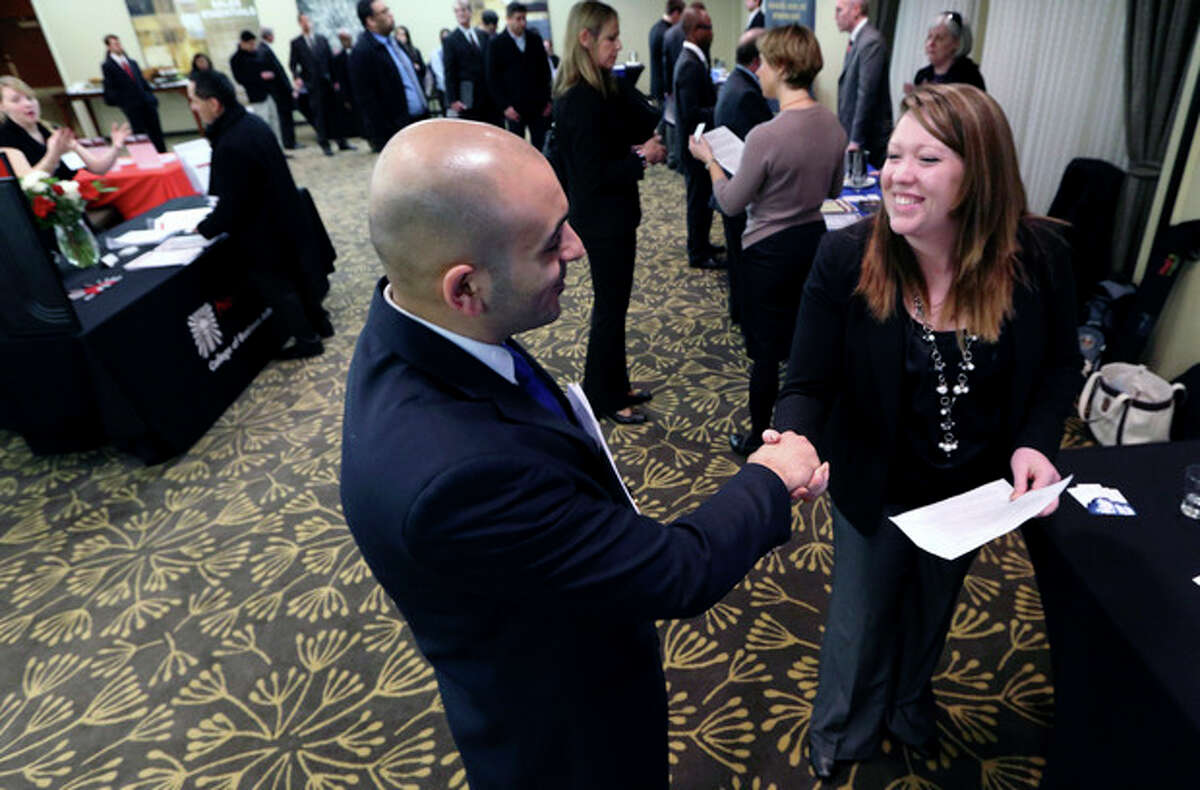 In this Monday, Feb. 25, 2013, photo, Sayed Mouawad, left, of Providence, R.I., shakes hands with Jillian Wallace of Matix, Inc., during a job fair in Boston. The number of people seeking U.S. unemployment aid fell to a seasonally adjusted 340,000 in the week ended March 2, driving down the four-week average to its lowest level in five years. (AP Photo/Michael Dwyer)