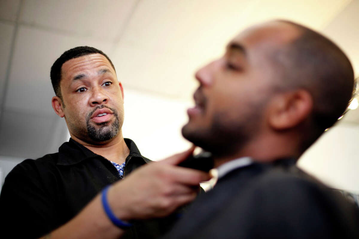 Dorsey Jackson trims Be-Emnet Zegeye's beard at his establishment Jackson's Barbershop, Friday, May 11, 2012, in Ardmore, Pa. Like many black Americans, Dorsey Jackson does not believe in gay marriage, but he wasn't disillusioned when Barack Obama became the first president to support it. The windows of his suburban Philadelphia barbershop still display an "Obama 2012" placard and another that reads "We've Got His Back." (AP Photo/Matt Rourke)