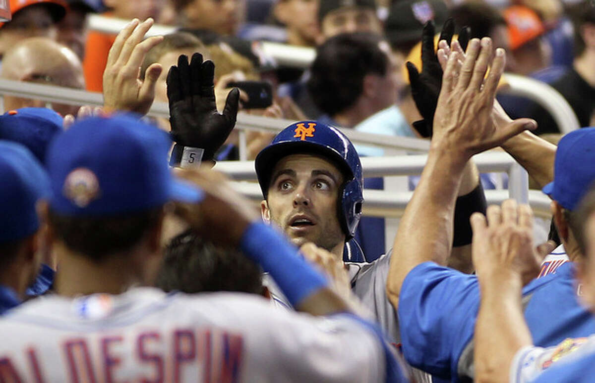 New York Mets' David Wright, center, celebrates in the dugout after hitting a third-inning home run against the Miami Marlins in a baseball game in Miami, Saturday, May 12, 2012. (AP Photo/J Pat Carter)