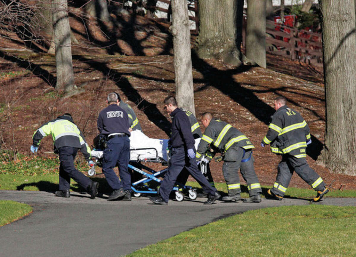A rescue crew wheels away a body that was found in the Five Mile River Saturday afternoon near the Darien/Norwalk line on Connecticut Avenue. Hour Photo / Danielle Robinson
