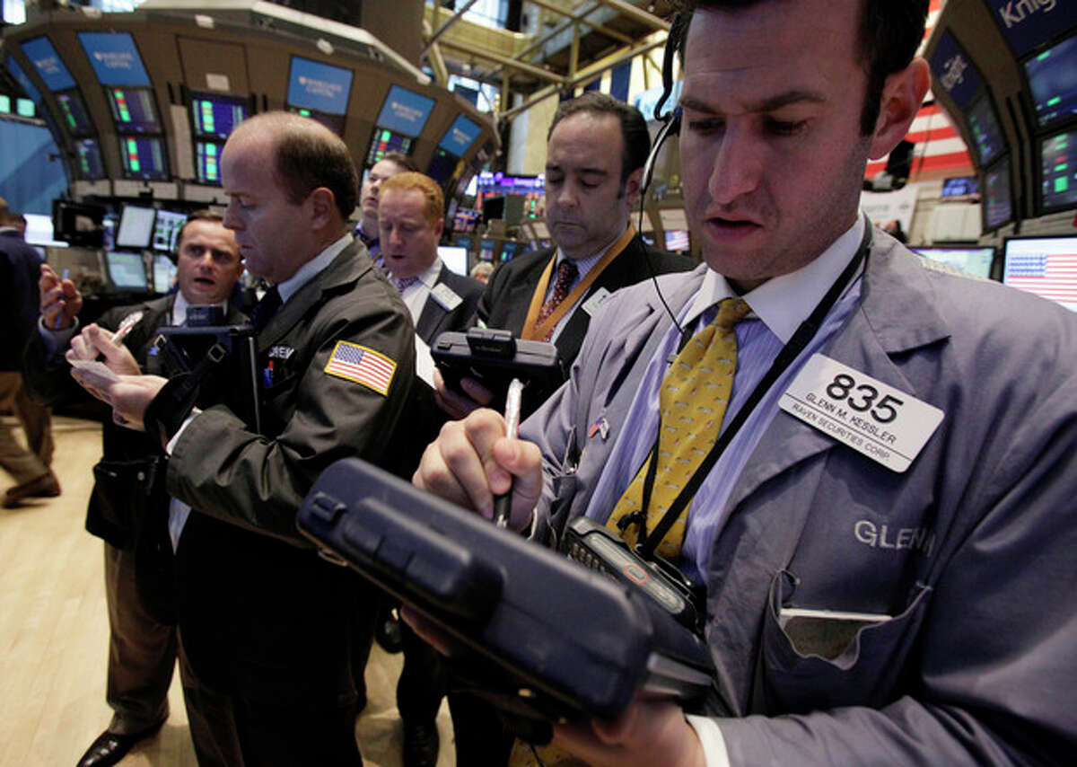 Traders gather at the post that handles HealthSpring on the floor of the New York Stock Exchange Monday, Oct. 24, 2011. HealthSpring rose 33 percent after Cigna said it will buy the health insurer for about $3.8 billion in cash.(AP Photo/Richard Drew)