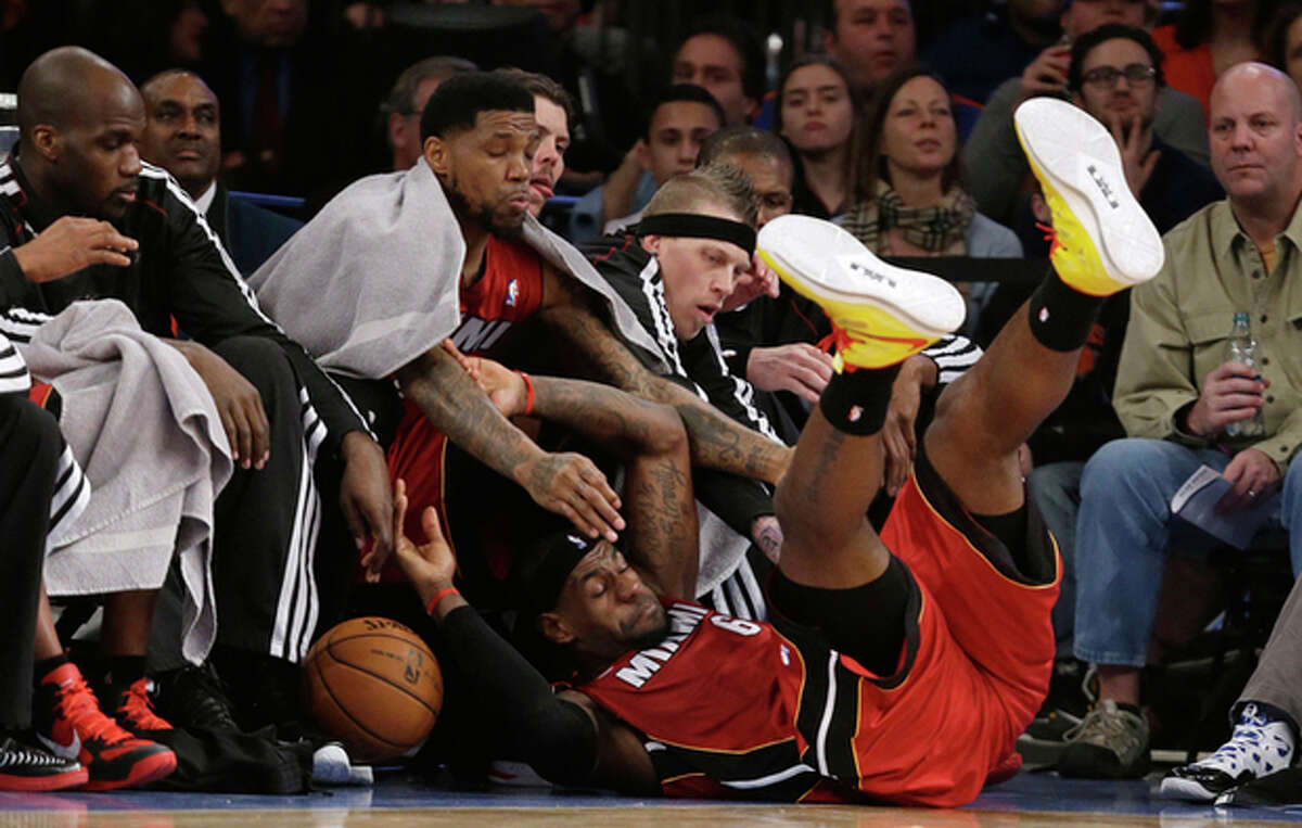 Miami Heat forward LeBron James (6) falls into the bench during the first half of an NBA basketball game against The New York Knicks at Madison Square Garden in New York, Sunday, March 3, 2013. (AP Photo/Kathy Willens)