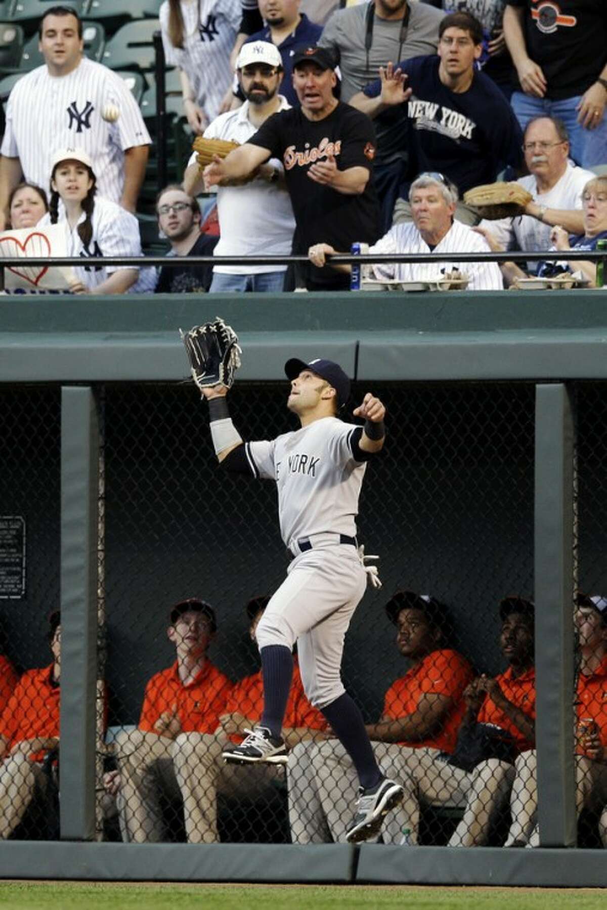 New York Yankees right fielder Nick Swisher leaps to catch a fly ball that was hit by Baltimore Orioles' J.J. Hardy in the first inning of a baseball game in Baltimore, Tuesday, May 15, 2012. (AP Photo/Patrick Semansky)