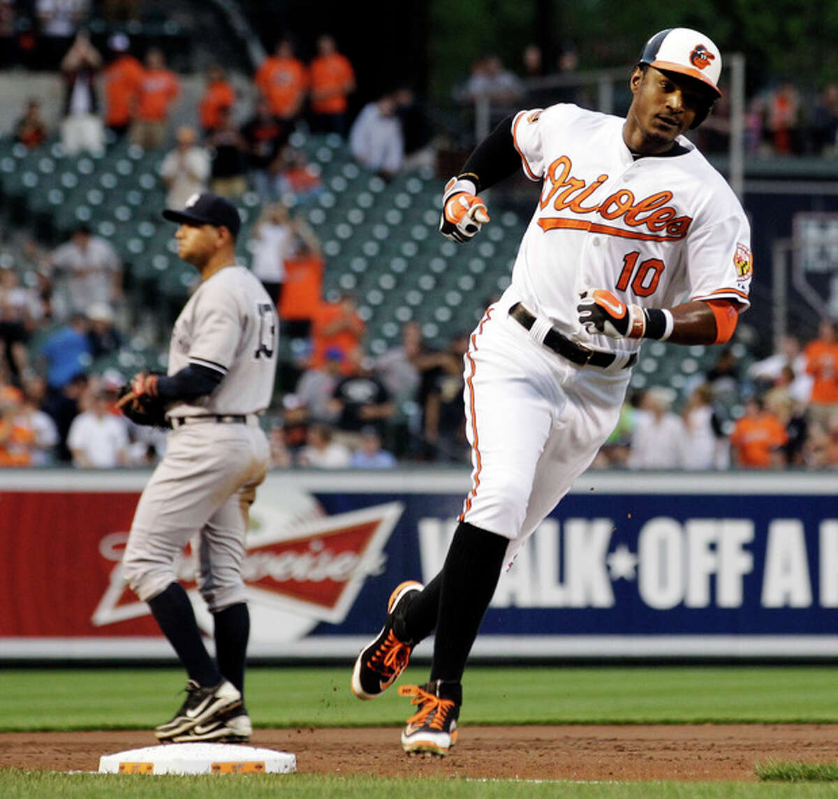 Baltimore Orioles' Adam Jones (10) rounds third base past New York Yankees third baseman Alex Rodriguez after hitting a solo home run in the second inning of a baseball game in Baltimore, Tuesday, May 15, 2012. (AP Photo/Patrick Semansky)