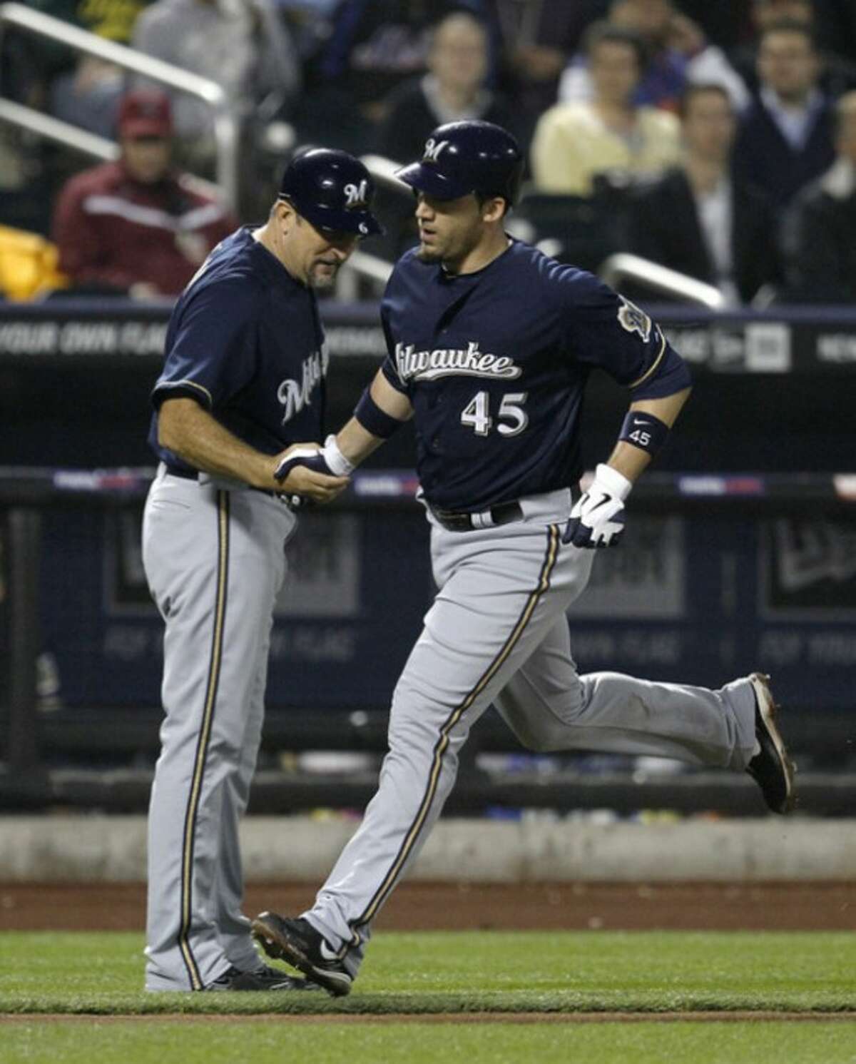 Milwaukee Brewers third base coach Ed Sedar congratulates Travis Ishikawa (45) as he rounds the bases on his solo home run off New York Mets pitcher Dillon Gee during the fifth inning of their baseball game at Citi Field in New York, Tuesday, May 15, 2012. (AP Photo/Kathy Willens)