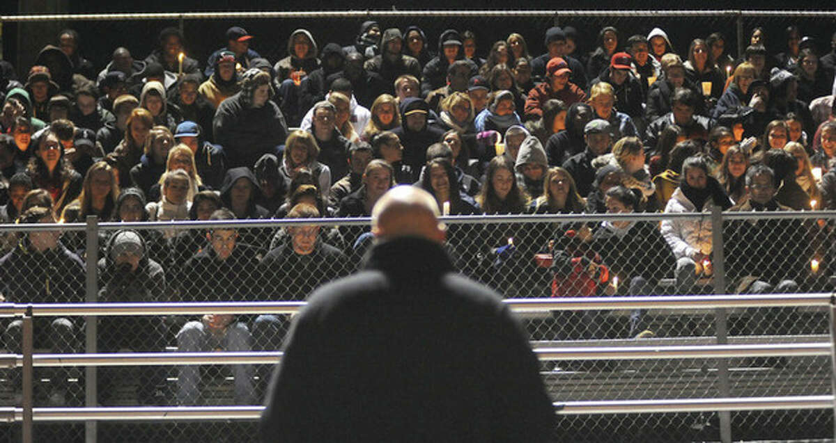 Hour photo / John Nash More than 800 mourners showed up at Casagrande Field at Brien McMahon High School Friday evening for a candlelight vigil in the memory of former Senators standout athlete James Shaw. The Rev. John Livingston of United Church of Rowayton, bottom center, addressed the crowd.