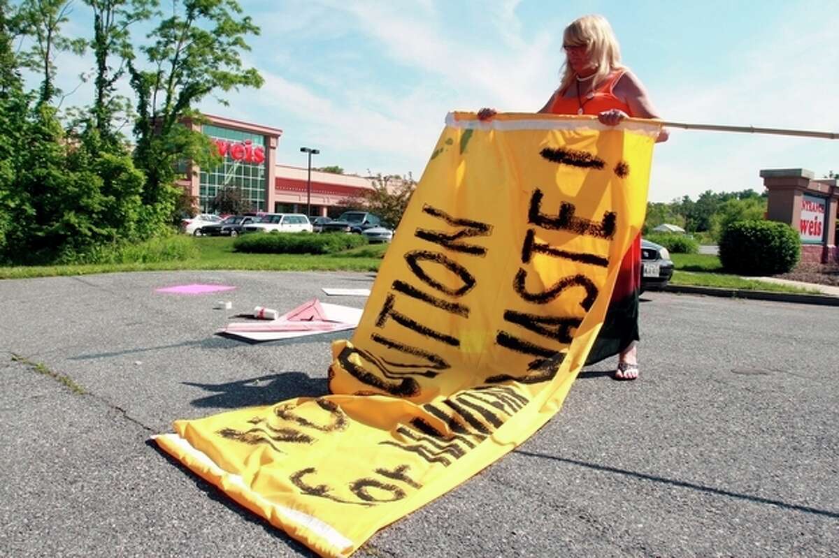 Occupy DC organizer Donna Plamondon packs up G8 Summitt protest signs in Thurmont, Md., on Friday, May 18, 2012, after a planned demonstrating along Route 15 never materialized. A lack of numbers seemed to be the major cause of the cancellation. (AP Photo/Timothy Jacobsen)