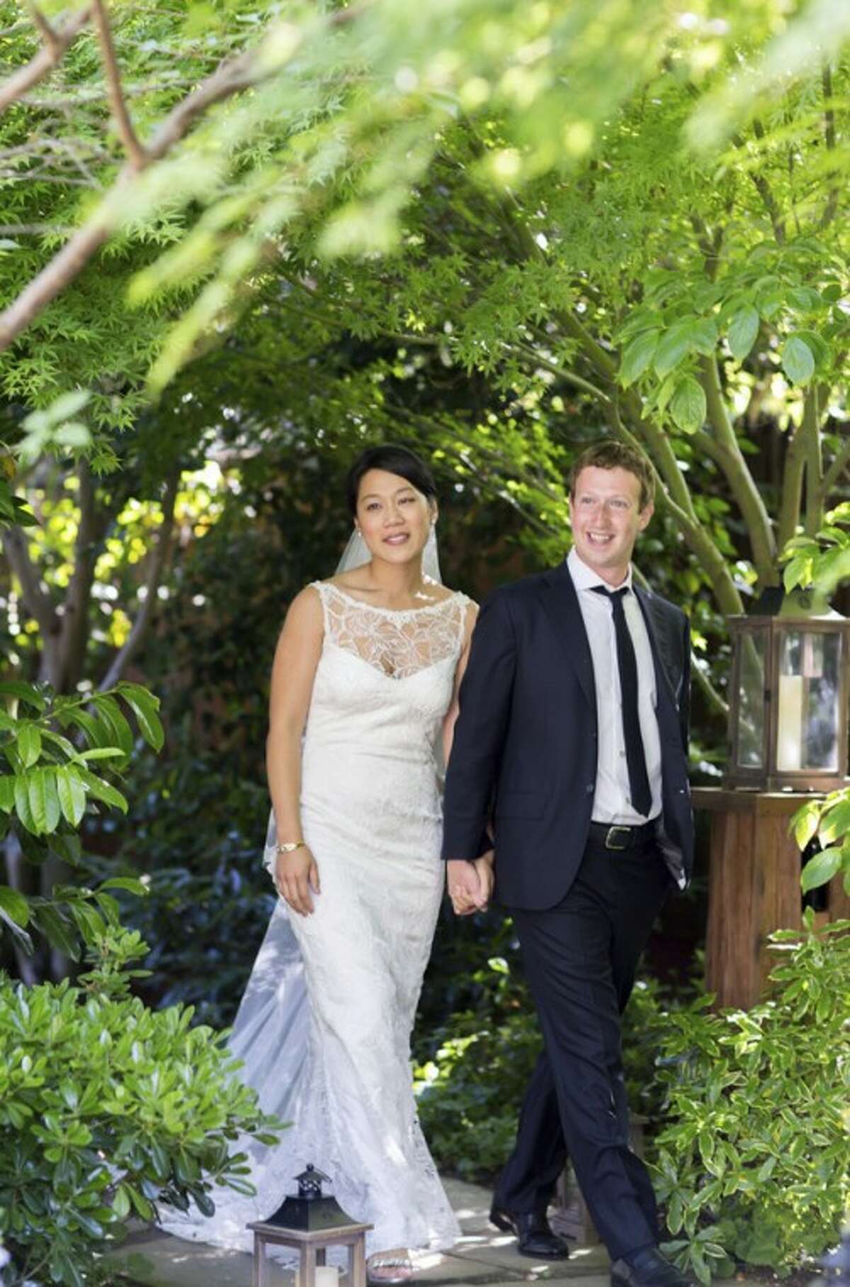 This photo provided by Facebook shows Facebook founder and CEO Mark Zuckerberg and Priscilla Chan at their wedding ceremony in Palo Alto, Calif., Saturday, May 19, 2012. Zuckerberg updated his status to "married" on Saturday. The ceremony took place in Zuckerberg's backyard before fewer than 100 guests, who all thought they were there to celebrate Chan's graduation. (AP Photo/Facebook, Allyson Magda Photography)