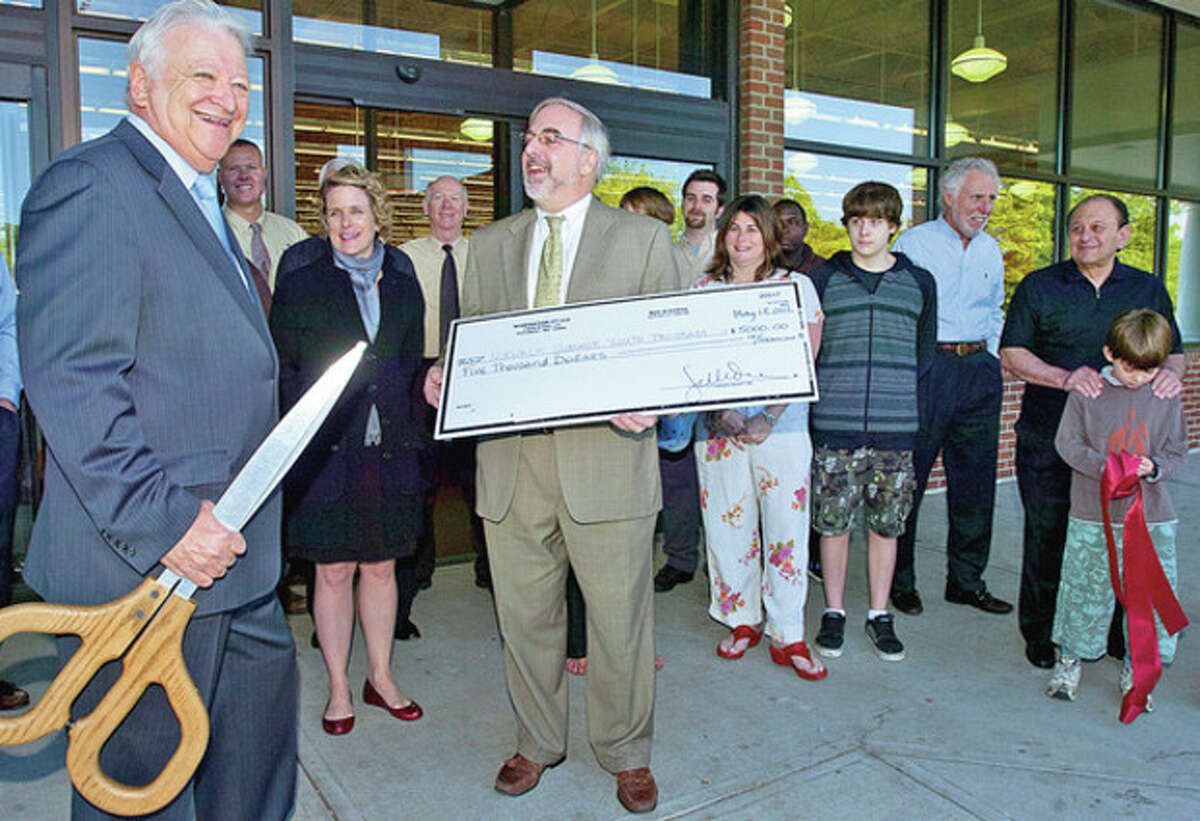 Norwalk mayor Richard Moccia is surprised by a $5000 donation to the City Youth Employment Program from Wine Nation CEO Thomas Trone during the ribbon cutting ceremony for their new store on Main Ave Friday. Hour photo / Erik Trautmann