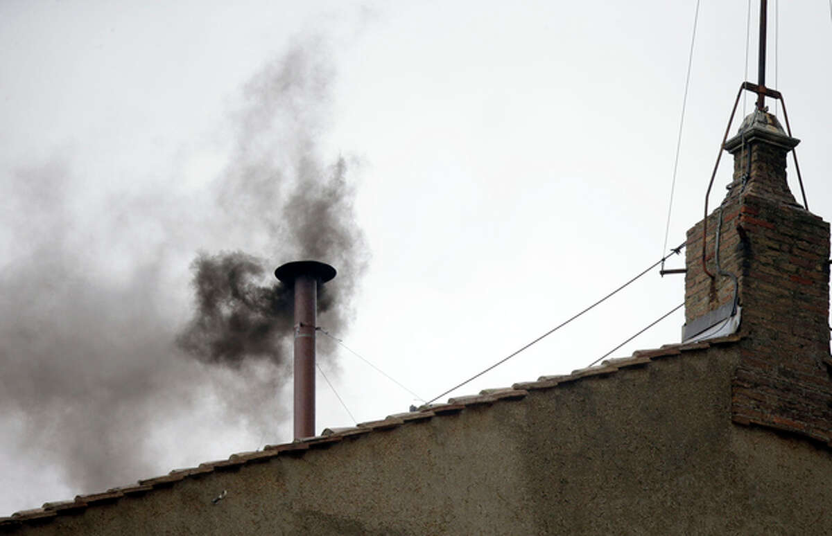 Black smoke emerges from the chimney on the roof of the Sistine Chapel, in St. Peter's Square at the Vatican, Wednesday, March 13, 2013. The black smoke indicates that the new pope has not been elected yet. (AP Photo/Gregorio Borgia)