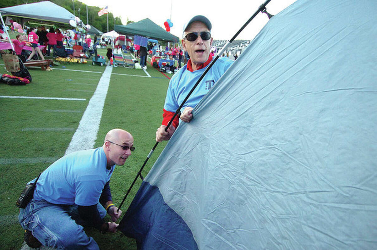 Hour Photo/ Alex von Kleydorff. L-R Chris Sanders and Jerry Rabin help to set up a tent for a neighbor at Relay for Life in Wilton.