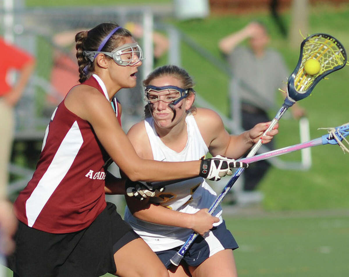 Hour photo/John Nash Weston's Catie Ledwick, right, protects the ball against the defense of Sacred Heart Academy's Alex Ryan during Thursday's CIAC Class S girls lacrosse playoff game in Weston.