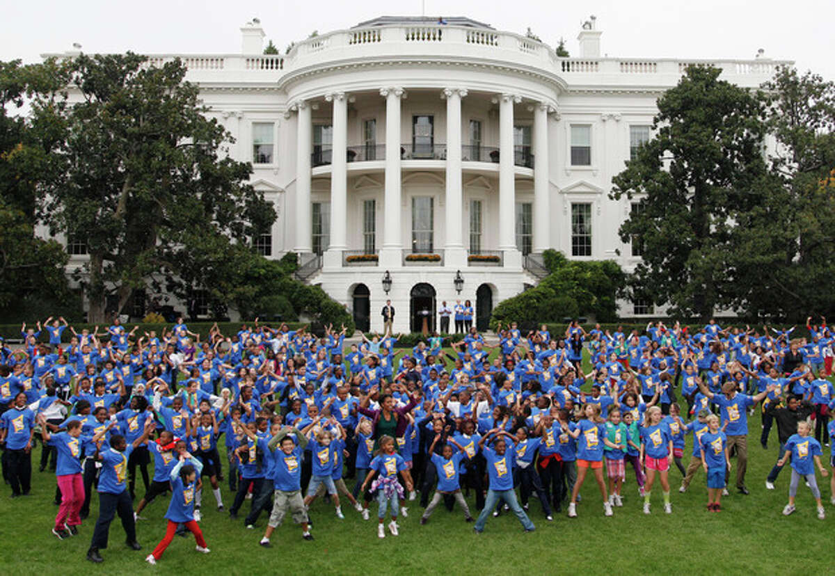 First lady Michelle Obama hosts local children on the South Lawn of the White House in Washington, Tuesday, Oct. 11, 2011, as they attempt to break the Guinness World Records title for the most people doing jumping jacks in a 24-hour period. (AP Photo/Pablo Martinez Monsivais)