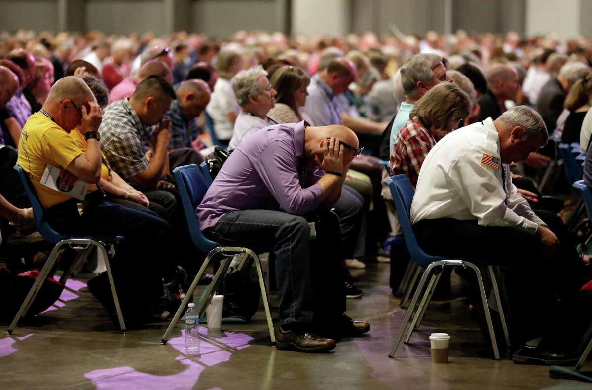 People pray during the annual meeting of the Southern Baptist Convention Tuesday, June 14, 2016, in St. Louis. (AP Photo/Jeff Roberson)