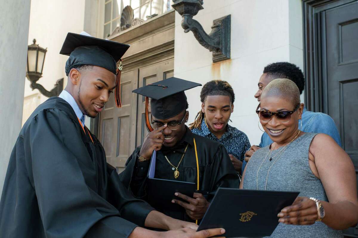 From left, Daiwon Nelson and Azonte Craddock show off their diplomas to Jamaul Wynter, Horace Edwards, and Shelleann Nelson after Bullard-Havens Technical High School commencement, held at the Klein Memorial Auditorium, in Bridgeport, Conn. on Tuesday, June 14, 2016.