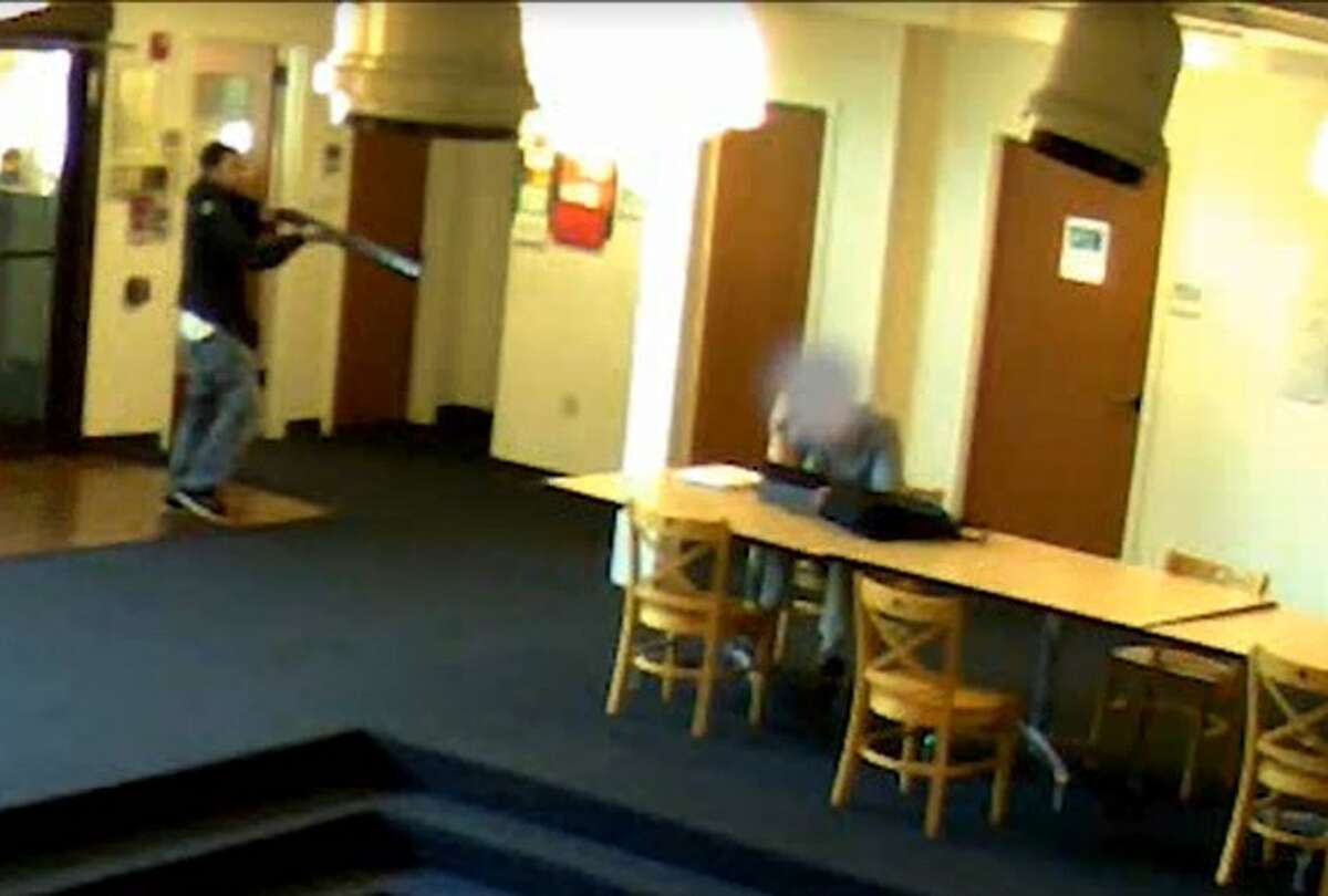 A man identified as Aaron Ybarra enters Otto Miller Hall on June 4, 2014, and points his gun at a student working on his computer.