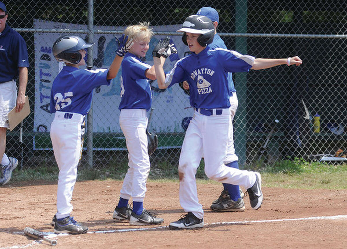 Rowayton Pizza's Bennett Close is greeted by teammates after home run vs. Sports Authority Sunday at the Rowayton little league Massey Cup championship. hour photo/Matthew Vinci