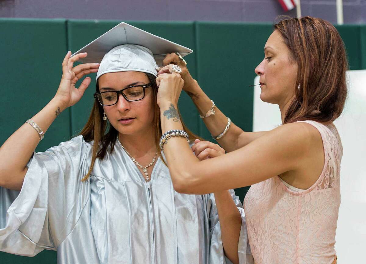Jessy Toro (right) helps her daughter Elisa Martinez with her cap prior to the Bridge Academy Nineteenth Annual Graduation held at the Thurgood Marshall Middle School, Bridgeport, CT on Tuesday, June 14, 2016.