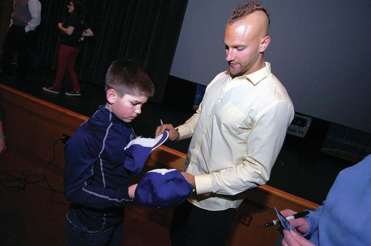 Hour photo/Alex von Kleydorff New York Giants linebacker Mark Herzlich signs some CT Challenge hats for 10-year-old cancer survivor Justin Ordway, who came from Southbury with his family to hear the player's talk.