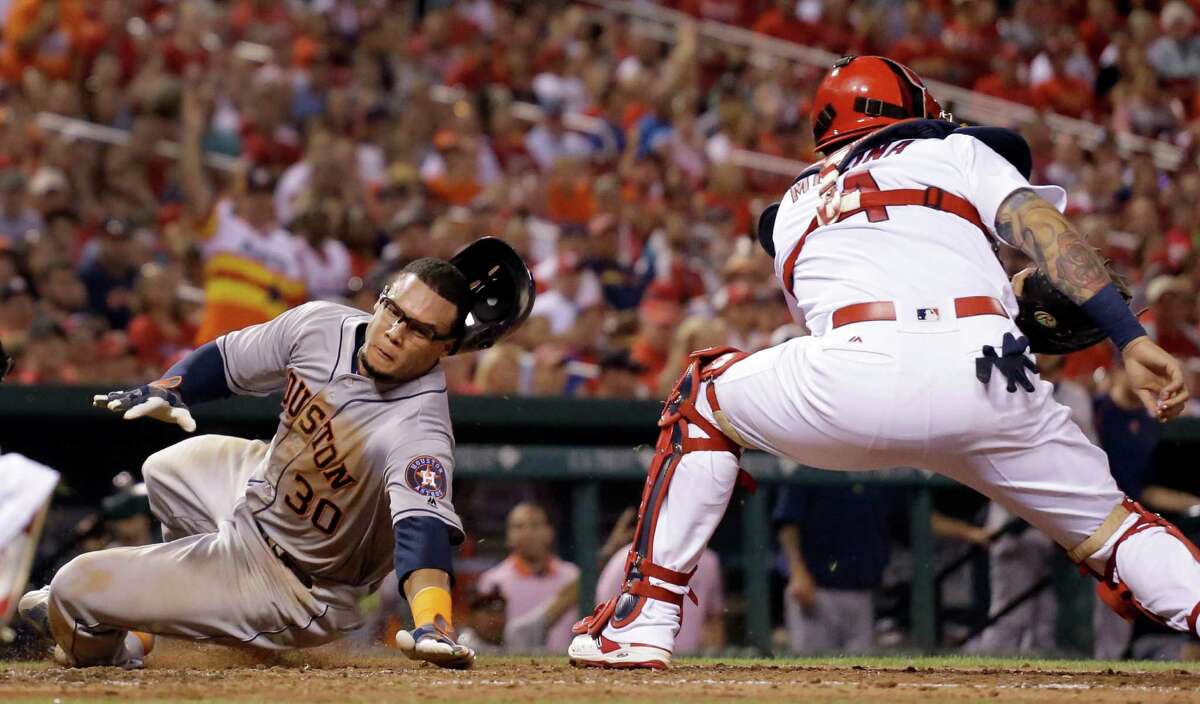 Houston Astros' Carlos Gomez, left, scores past St. Louis Cardinals catcher Yadier Molina during the seventh inning of a baseball game Tuesday, June 14, 2016, in St. Louis. (AP Photo/Jeff Roberson)