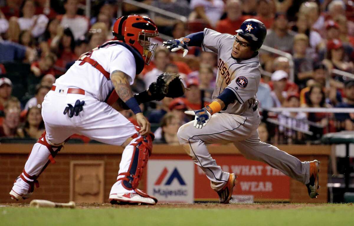 Houston Astros' Carlos Gomez, right, scores past St. Louis Cardinals catcher Yadier Molina during the seventh inning of a baseball game Tuesday, June 14, 2016, in St. Louis. (AP Photo/Jeff Roberson)