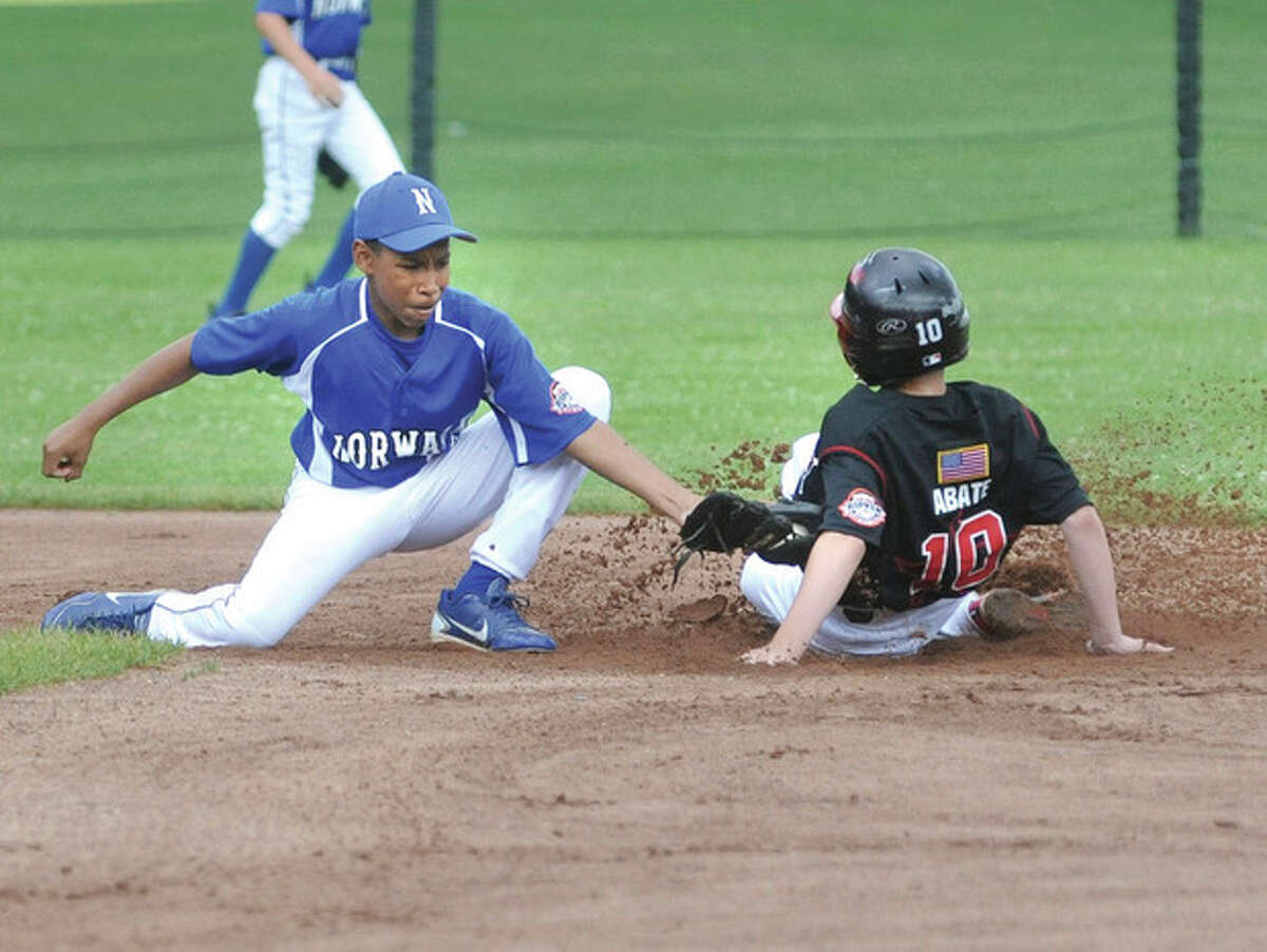   Hour photo/Matthew Vinci Norwalk #shortstop Matt Saint-Loius applies a late tag to New Canaan's Dillon Abate on a play at second base during Monday's Cal Ripken Baseball 12-year-old district tournament contest. New Canaan scored a 10-6 victory.