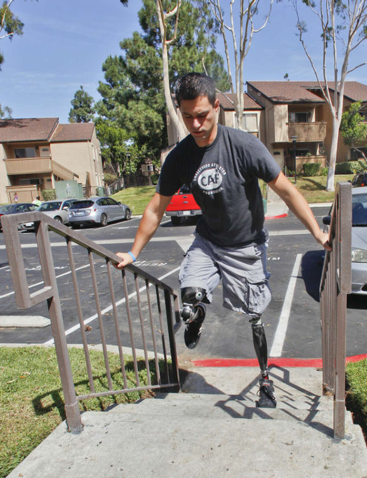 FILE - In this Thursday, Oct. 4, 2012 file photo, U.S. Marine Cpl. Daniel Riley, 21, navigates the steps outside his apartment on his prosthetic legs in San Diego, Calif. Riley lost both legs to an IED in Afhganistan. Learning to walk on his prosthetic legs was "like kicking a soccer ball in a swimming pool." Nearly 2,000 American troops have lost a leg, arm, foot or hand in Iraq or Afghanistan, and their sacrifices have led to advances in the immediate and long-term care of survivors, as well in the quality of prosthetics that are now so good that surgeons often chose them over trying to save a badly mangled leg. (AP Photo/Lenny Ignelzi)