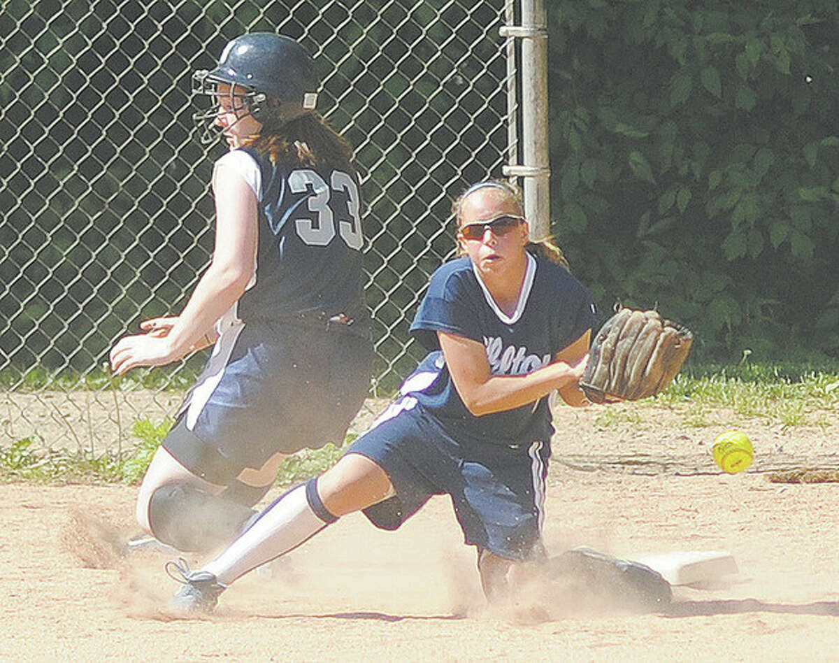Hour Photo/John Nash - Wilton third baseman Amy Salvato, right, can't come up with the throw from the outfielder as Staples Shannon Connors slide safe into the base during the fourth inning of Friday's game.
