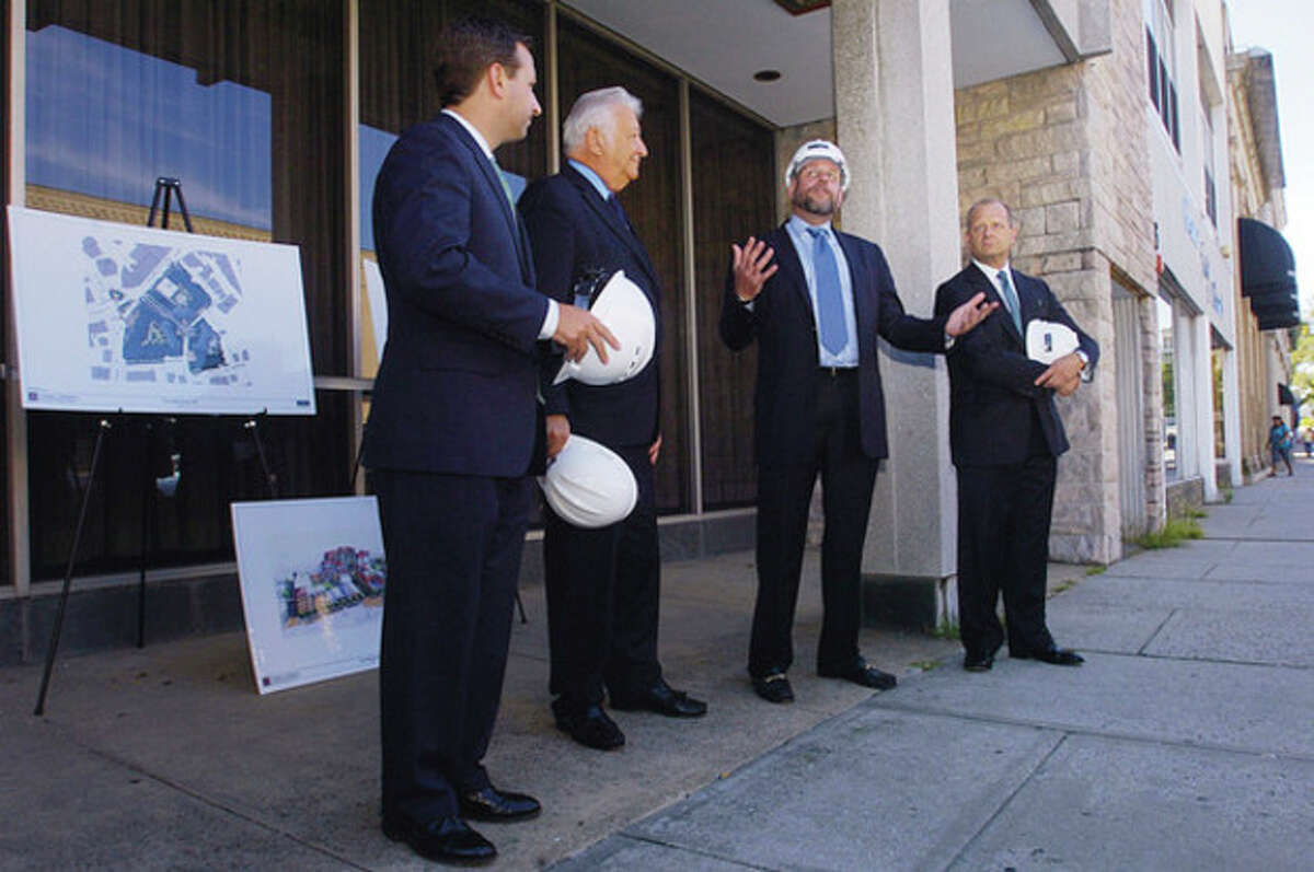 Hour photo / Erik Trautmann From left, State Sen. Bob Duff, D-25, Mayor Richard A. Moccia and Emil Albanese, chairman of the Norwalk Redevelopment Agency, listen as POKO CEO Ken Olsen speaks during a ceremonial groundbreaking on Wall St. Friday.