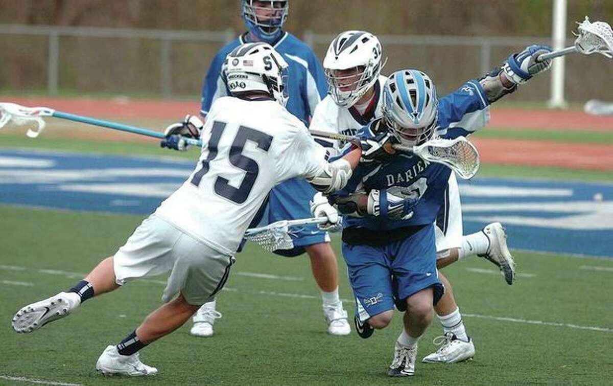 Hour photo/Alex von Kleydorff Staples Will Johnson (15) engages in some close order combat against William Hammermick of Darien during Tuesday's game in Westport. The two squads battled tooth-and-nail before the visiting Blue Wave emerged with a 5-3 victory