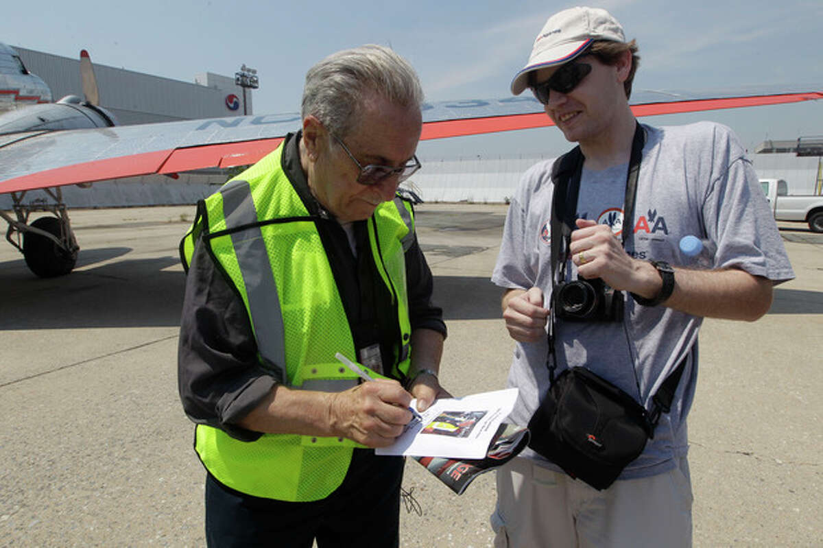 Azriel "Al" Blackman signs an autograph for an aviation enthusiast after flying in a DC-3, Wednesday, July 18, 2012 in New York. American Airlines is celebrating the 70-year service of a New York City mechanic who says he has no plans to retire. Azriel "Al" Blackman was 16 years old when he started as an apprentice mechanic in July of 1942. (AP Photo/Mary Altaffer)