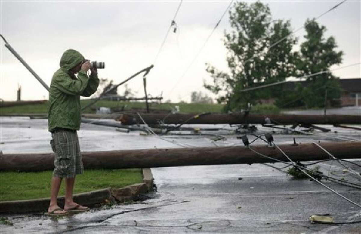 A photographer shoots some of the damage near St. Joseph Hospital in Joplin, Mo., after the town was hit by a tornado on Sunday, May 22, 2011. (AP Photo/The Wichita Eagle, Jaime Green)