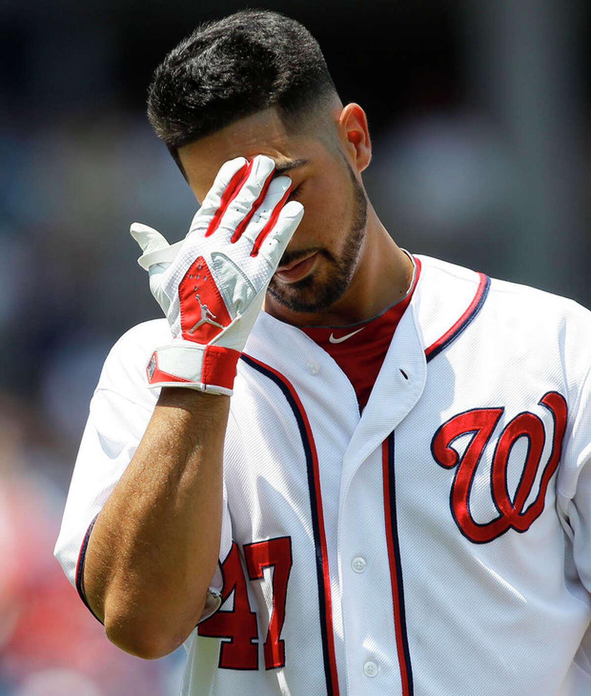 Washington Nationals starting pitcher Gio Gonzalez wipes his brow as he walks back to the dugout after grounding out in the third inning of a baseball game against the New York Mets on Thursday, July 19, 2012, in Washington. (AP Photo/Carolyn Kaster)