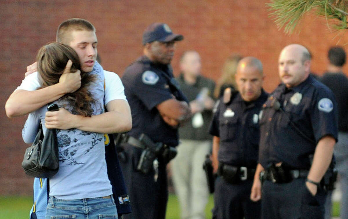 Eyewitness Jacob Stevens, 18, hugs his mother Tammi Stevens after being interview by police outside Gateway High School where witnesses were brought for questioning Friday, July 20, 2012 in Aurora, Colo. A gunman wearing a gas mask set off an unknown gas and fired into the crowded movie theater killing 12 people and injuring at least 50 others, authorities said. (AP Photo/The Denver Post, RJ Sangosti) TV, INTERNET AND MAGAZINES CALL FOR RATES AND TERMS