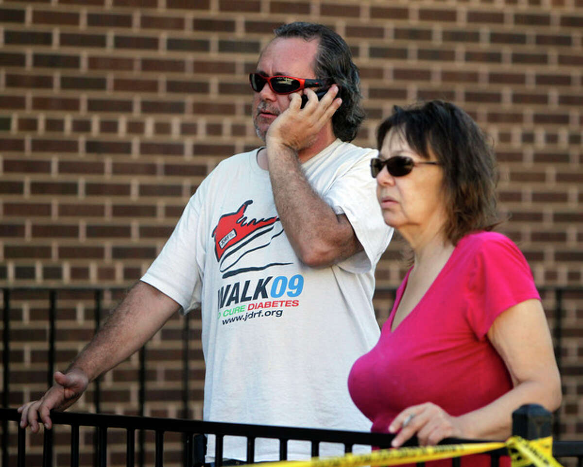 John Priest, left, and Vory Boots watch the police action at an apartment where the suspect in a theatre shooting lived in Aurora, Colo., on Friday, July 20, 2012. The couple were evacuated from their apartment across from the suspects. As many as 12 people were killed and 50 injured at a shooting at the Century 16 movie theatre on Friday. The suspect is identified as 24-year-old James Holmes. (AP Photo/Ed Andrieski)
