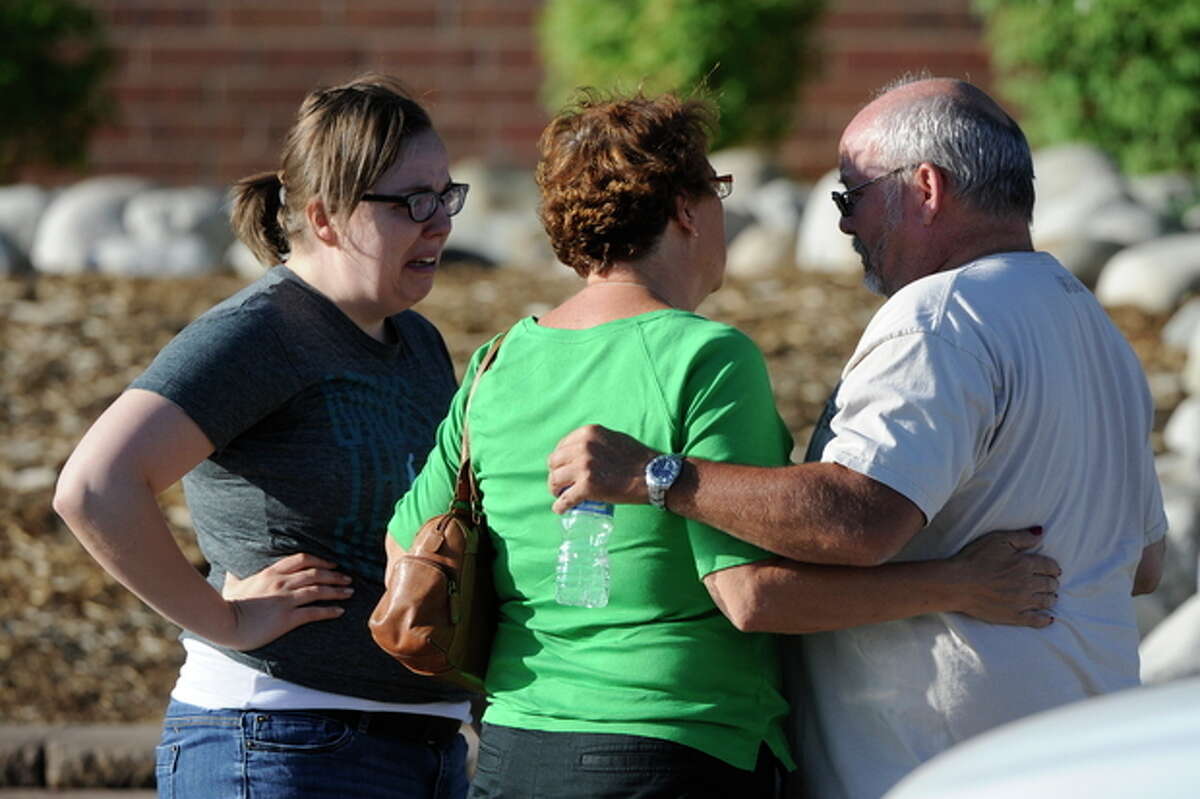 Tom Sullivan talks with family members at Gateway High School in Aurora, Colo., where witnesses we being interviewed by authorities Friday July 20, 2012. A gunman wearing a gas mask set off an unknown gas and fired into the crowded movie theater killing 12 people and injuring at least 50 others, authorities said. (AP Photo/The Denver Post, Craig F. Walker) TV, INTERNET AND MAGAZINES CALL FOR RATES AND TERMS