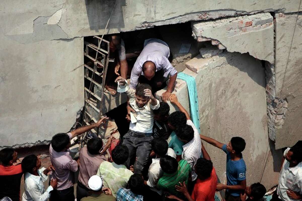 A man who was trapped in an eight-story building housing several garment factories is rescued after the structure collapsed in Savar, near Dhaka, Bangladesh, Wednesday, April 24, 2013. The building collapsed near Bangladesh's capital Wednesday morning, killing dozens of people and trapping many more in the rubble, officials said. (AP Photo/ A.M. Ahad)