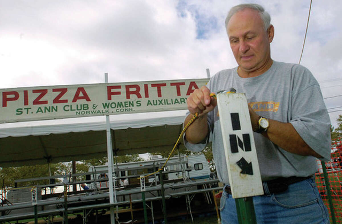 Ken Romano helps set up the St. Ann' Pizza Fritta booth at Veteran's Park Thursday in preparation for this year's Norwalk Seaport Association Oyster Festival.
