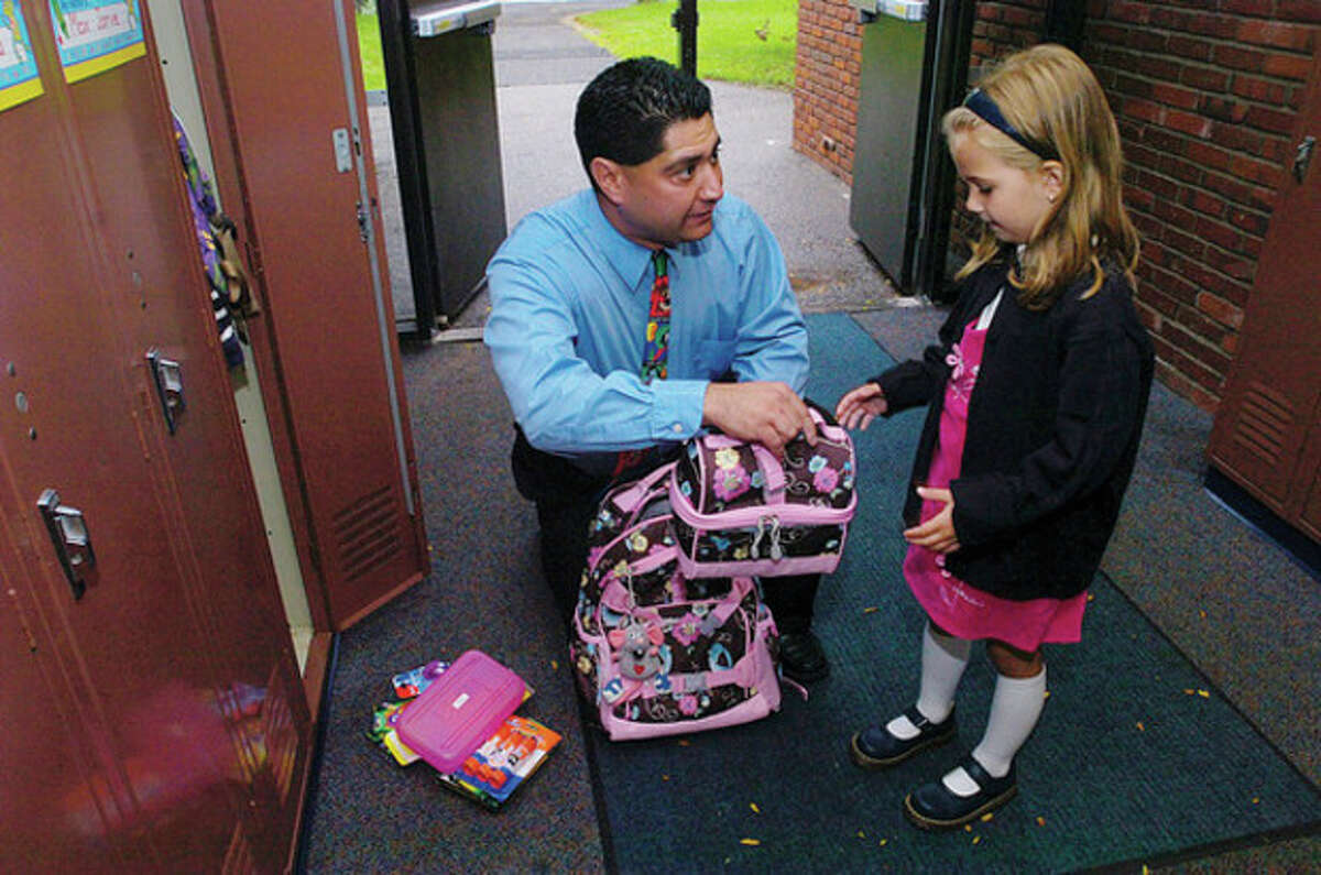 Miller Driscoll School kindergarten teacher Sal Giaimo helps Melanie Rutkowski find her locker on the first day of school on Tuesday. Hour photo / Erik Trautmann