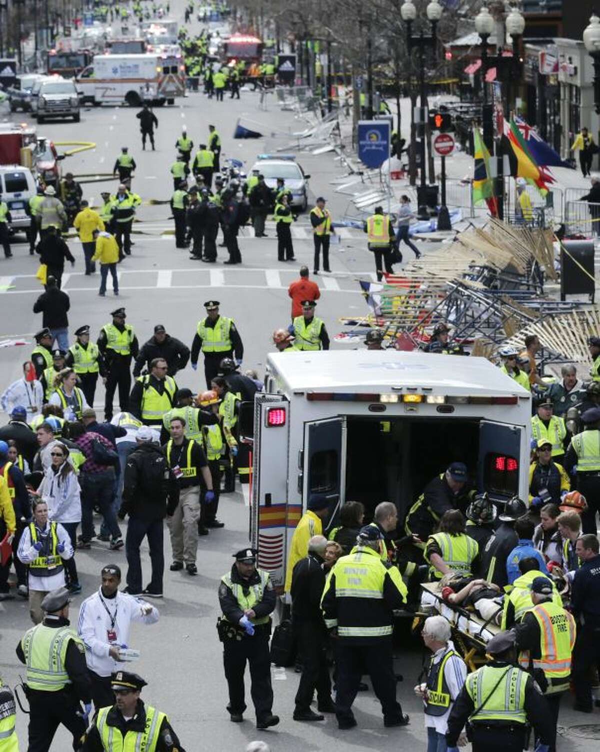 Medical workers aid injured people at the finish line of the 2013 Boston Marathon following an explosion in Boston, Monday, April 15, 2013. Two explosions shattered the euphoria of the Boston Marathon finish line on Monday, sending authorities out on the course to carry off the injured while the stragglers were rerouted away from the smoking site of the blasts. (AP Photo/Charles Krupa)
