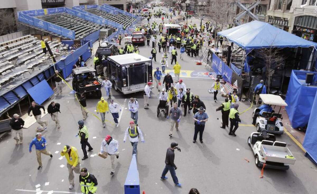 Police clear the area at the finish line of the 2013 Boston Marathon following an explosion in Boston, Monday, April 15, 2013. Two explosions shattered the euphoria of the Boston Marathon finish line on Monday, sending authorities out on the course to carry off the injured while the stragglers were rerouted away from the smoking site of the blasts. (AP Photo/Charles Krupa)
