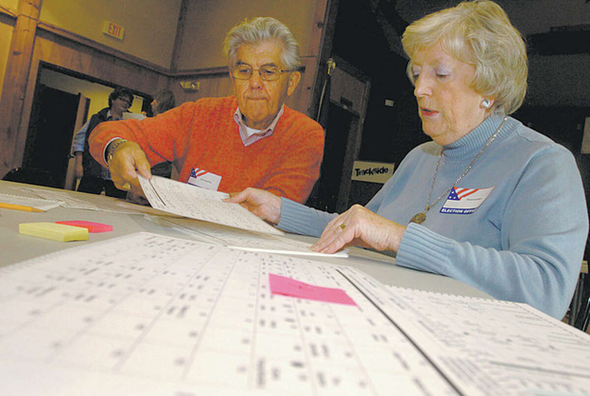 Volunteers Dick Martin and Paula Byrdy assist the Registrars of Voters Office last year while conducting an audit of Wilton's District 2 election results, as per state requirement. File photo / Erik Trautmann