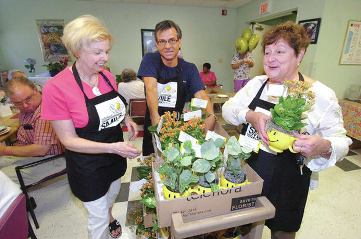Hour photo / Alex von Kleydorff Make someone smile day From left, Bunnie Hovan with Hovans Florist in Stratford, JP Licari with Licari's Floral Design in Norwalk, and Sue Wall with Hansen's Floral Arts in Fairfield pass around flowers to residents of Ludlow Commons for Teleflora's "Make someone smile day" Monday.