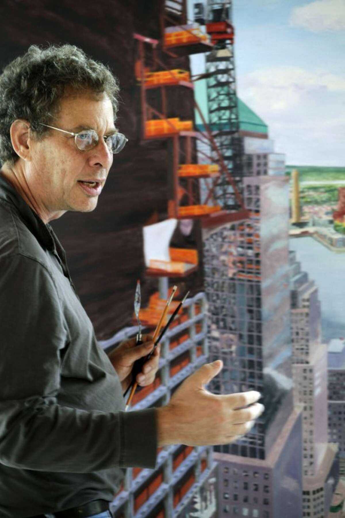 In this Aug. 25, 2011 photo, artist Todd Stone stands next to a painting of the World Trade Center in his studio, in New York. Stone is among the artists who are showing their works in exhibitions commemorating the 10th anniversary of the terrorist attacks. At least two dozen Sept. 11-related museum and gallery exhibitions are being presented throughout the city. (AP Photo/Mark Lennihan)