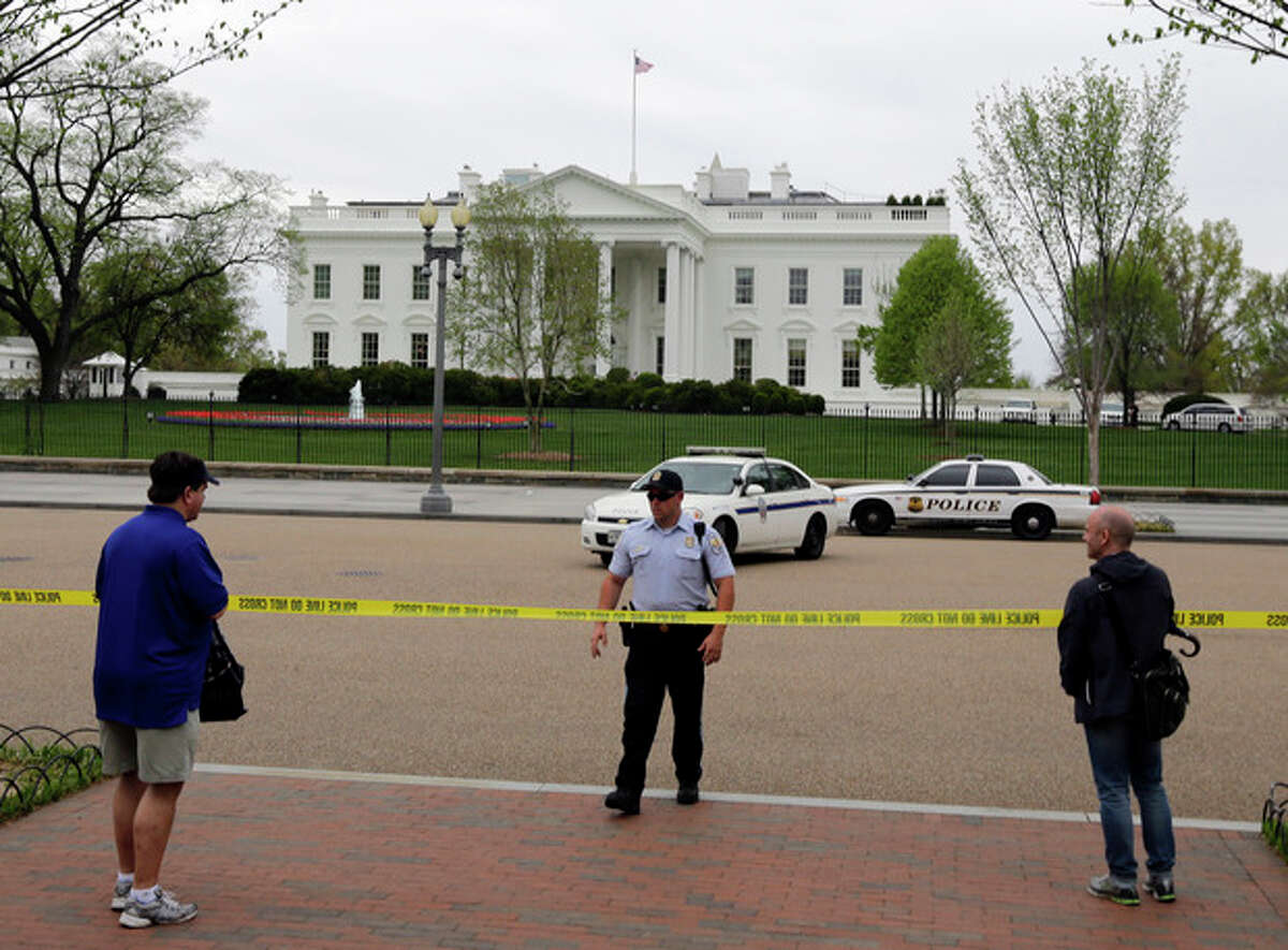 People stand behind police tape after law enforcement closed down Pennsylvania Avenue in front of the White House Monday, April 15, 2013 in Washington. (AP Photo/Alex Brandon)