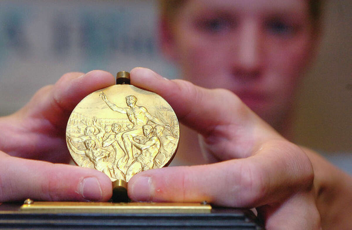 Hour Photo/ Alex von Kleydorff. Grandson Edward Stolarski holds 4 state championship swimming tittles holds the Gold Medal from the 1948 London olympics his Grandmother won in the 4x100 Relay