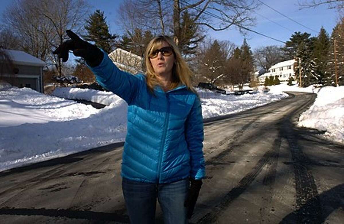 Nora King points out where through traffic on Old Field Road In Rowayton causes dangers to residents. The City has rejected the use of speed bumps on the road. Speed humps on a similar cut-through on Burchard Lane diverted traffic to Old Field. Hour photo / Erik Trautmann